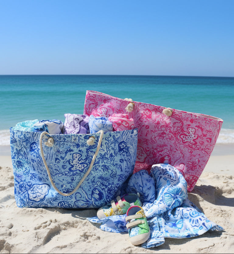 Blue and pink patterned bag with baby items including a blanket and shoes on a beige background